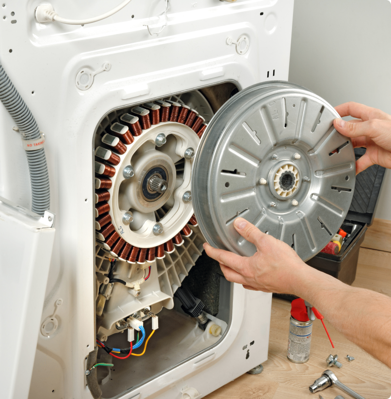 Person repairing washing machine motor assembly.