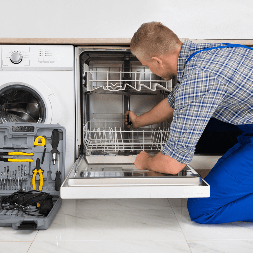 h1 05 Technician repairing dishwasher with toolset nearby.